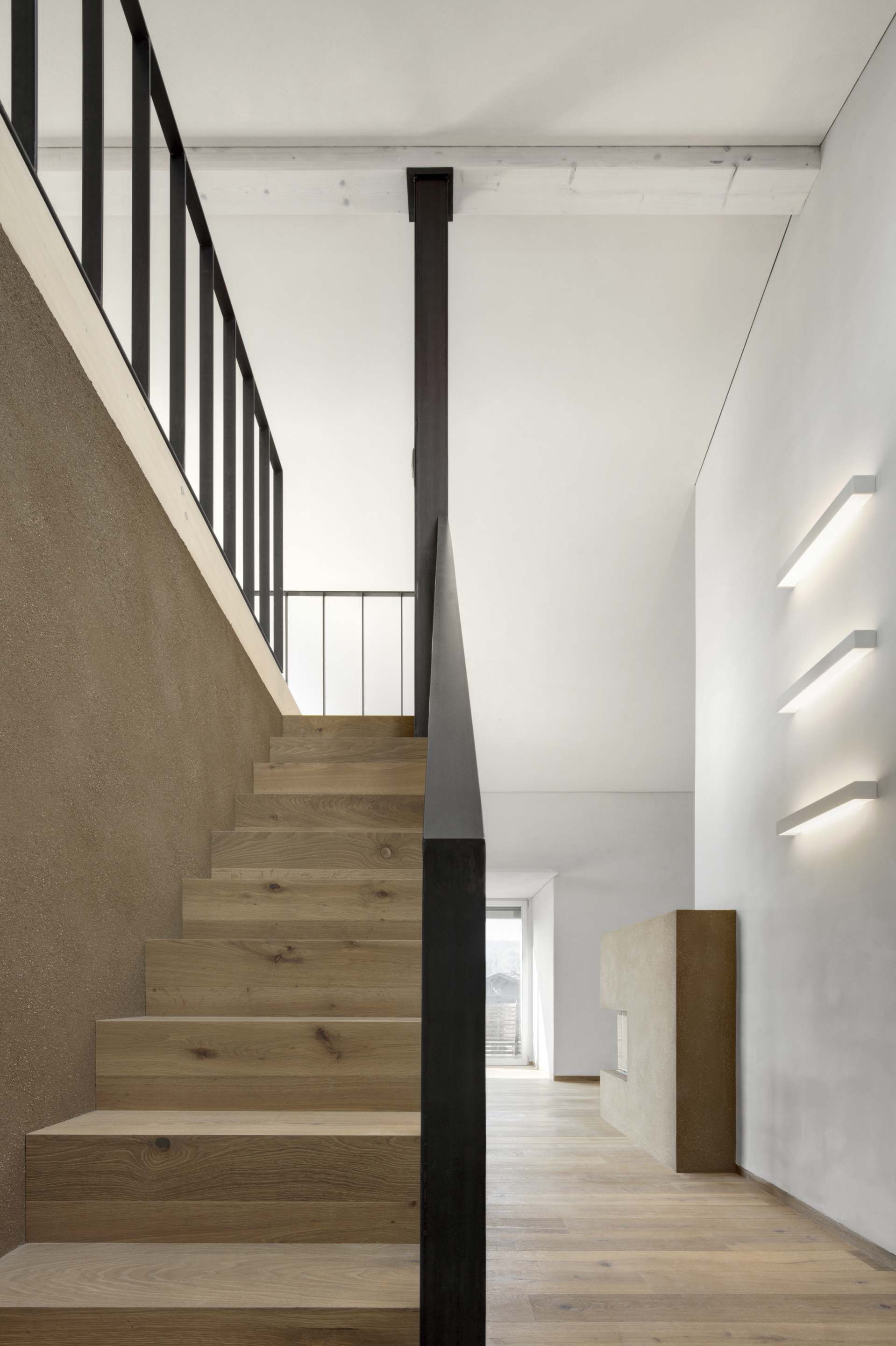 Matteo Brioni's coarse-grained clay plaster MultiTerra Smooth Cacao and Panna colors installed on walls, ceilings and furnitures in a private house in Brunico by Pedevilla Architects