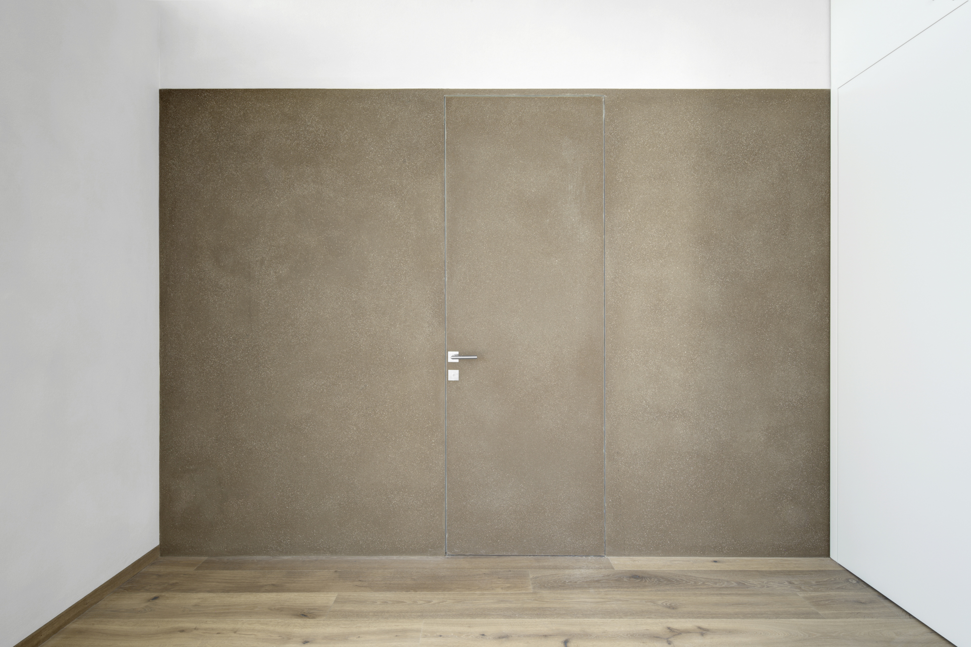 Matteo Brioni's coarse-grained clay plaster MultiTerra Smooth Cacao and Panna colors installed on walls, ceilings and furnitures in a private house in Brunico by Pedevilla Architects