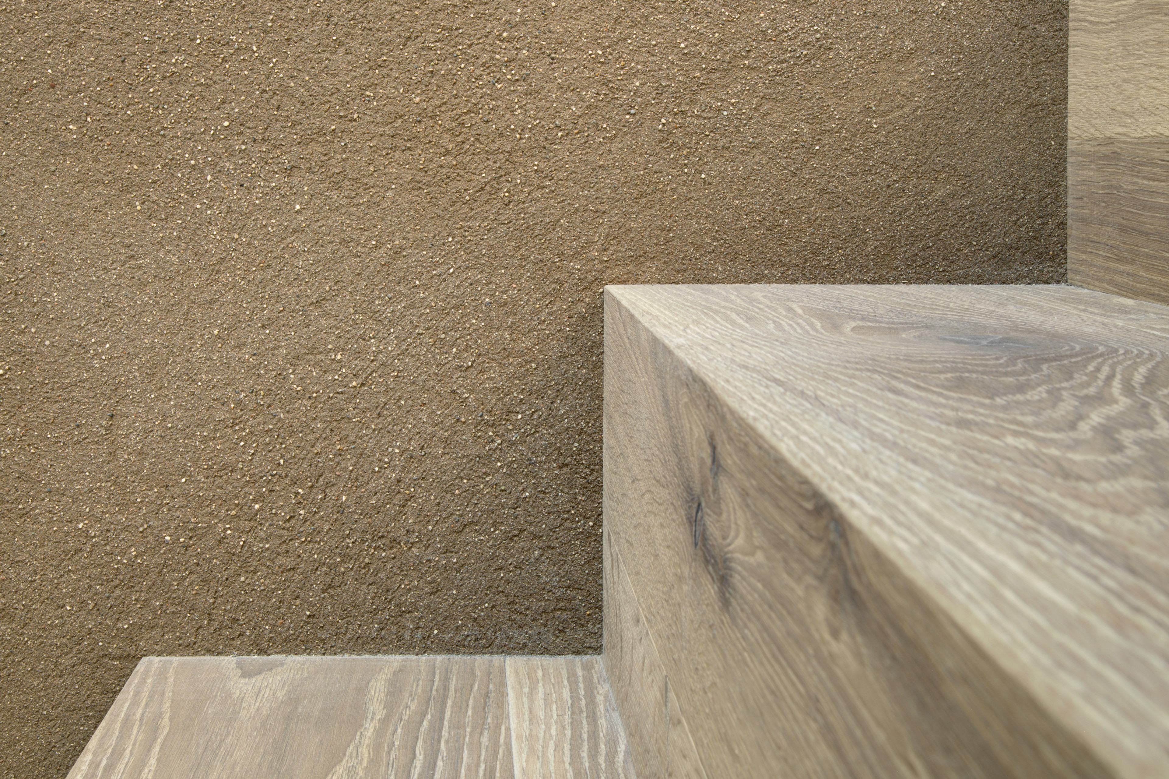 Matteo Brioni's coarse-grained clay plaster MultiTerra Smooth Cacao and Panna colors installed on walls, ceilings and furnitures in a private house in Brunico by Pedevilla Architects