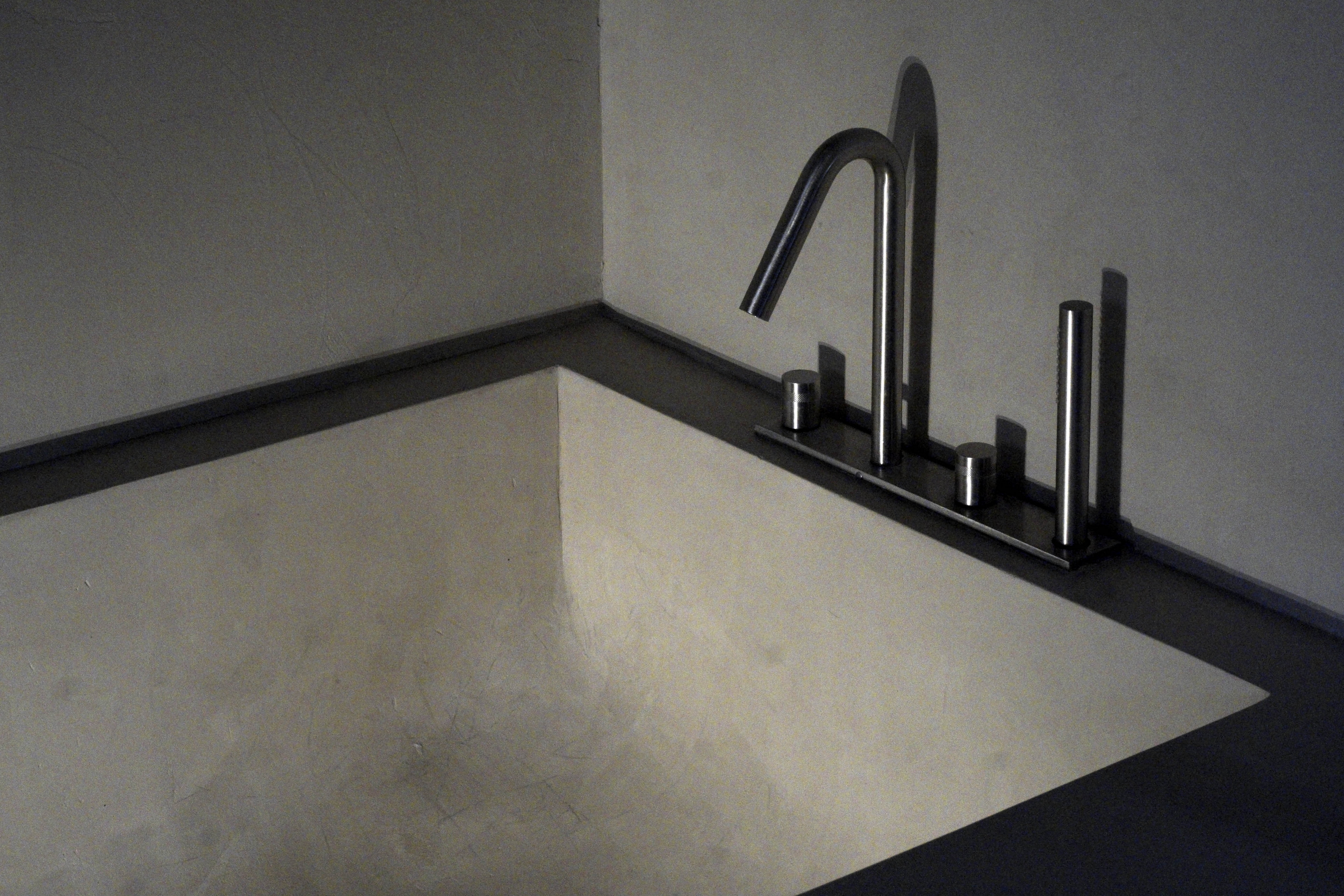 Matteo Brioni's fine-grained clay plaster TerraVista Smooth Sale Grigio (gray salt) color applied on bathroom surfaces in a private house in Milan by Ciro Massaro