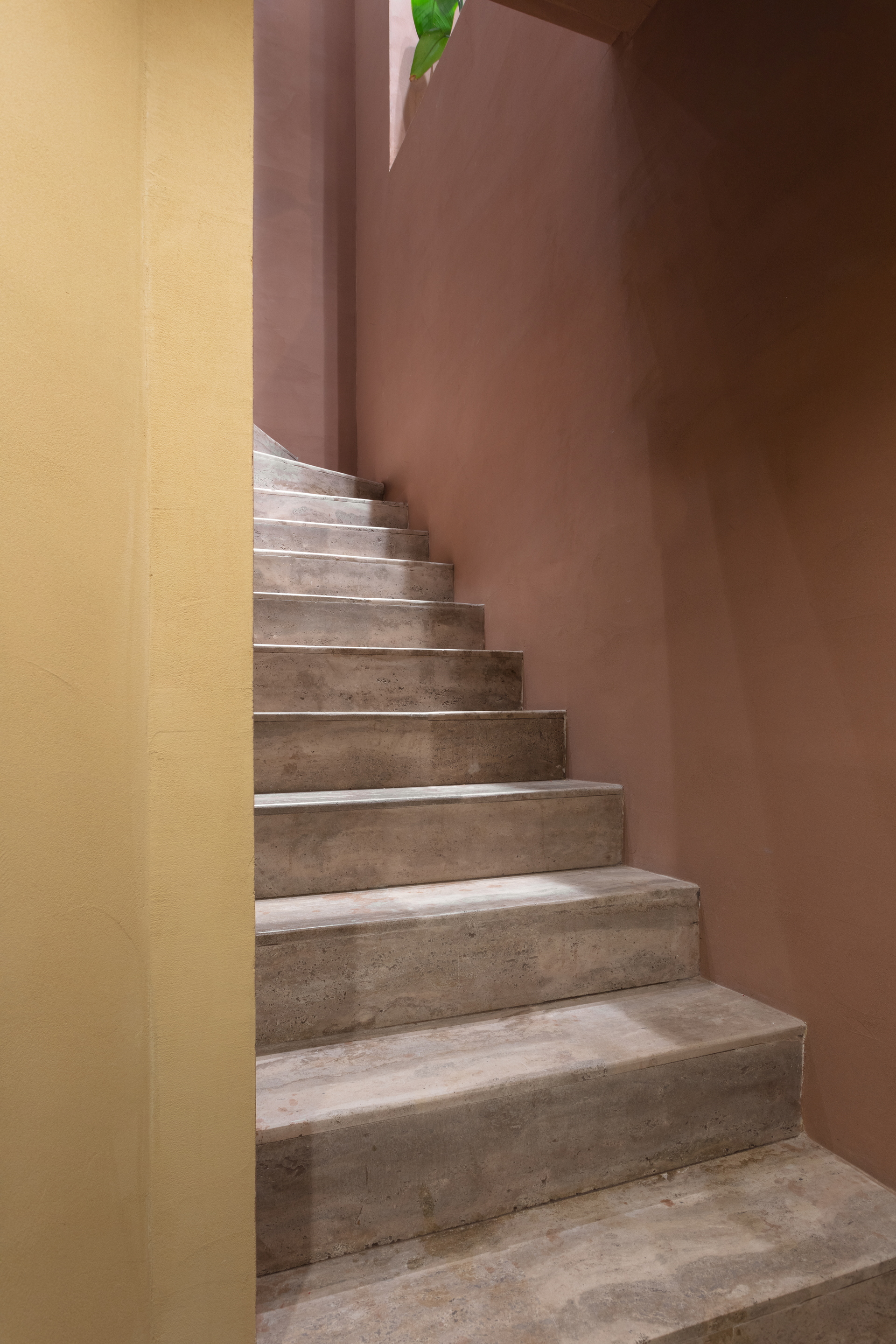 Matteo Brioni's reinforced fine-grained clay plaster TerraVista Plus Smooth Cammeo (cameo) and Senape (mustard) colors applied on the staircase walls of the Profumo shop in Naples, project by Primo Atelier, photo by Carlo Oriente