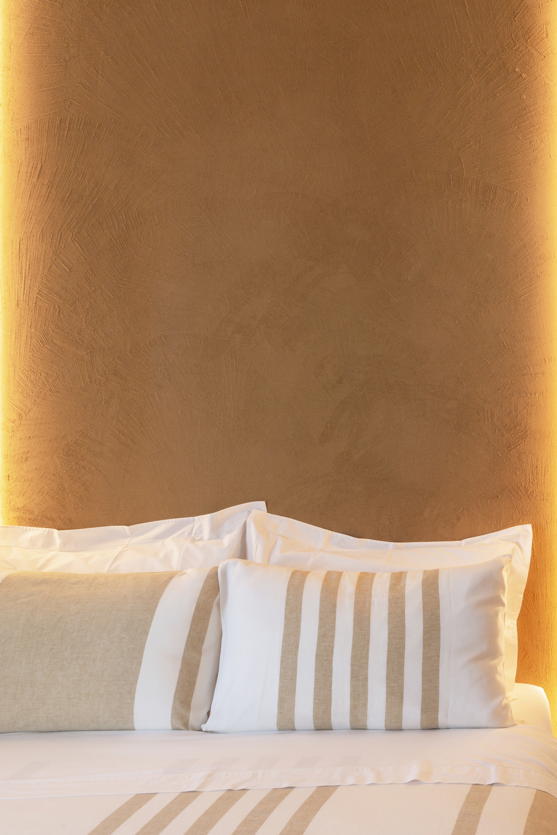 Medium-grained clay plaster TerraVista Structured Senape (mustard) color applied to walls in the Locanda Remare hotel in Cesenatico. Project by Francesco Gasperini, photo by Angelo Ciccolo