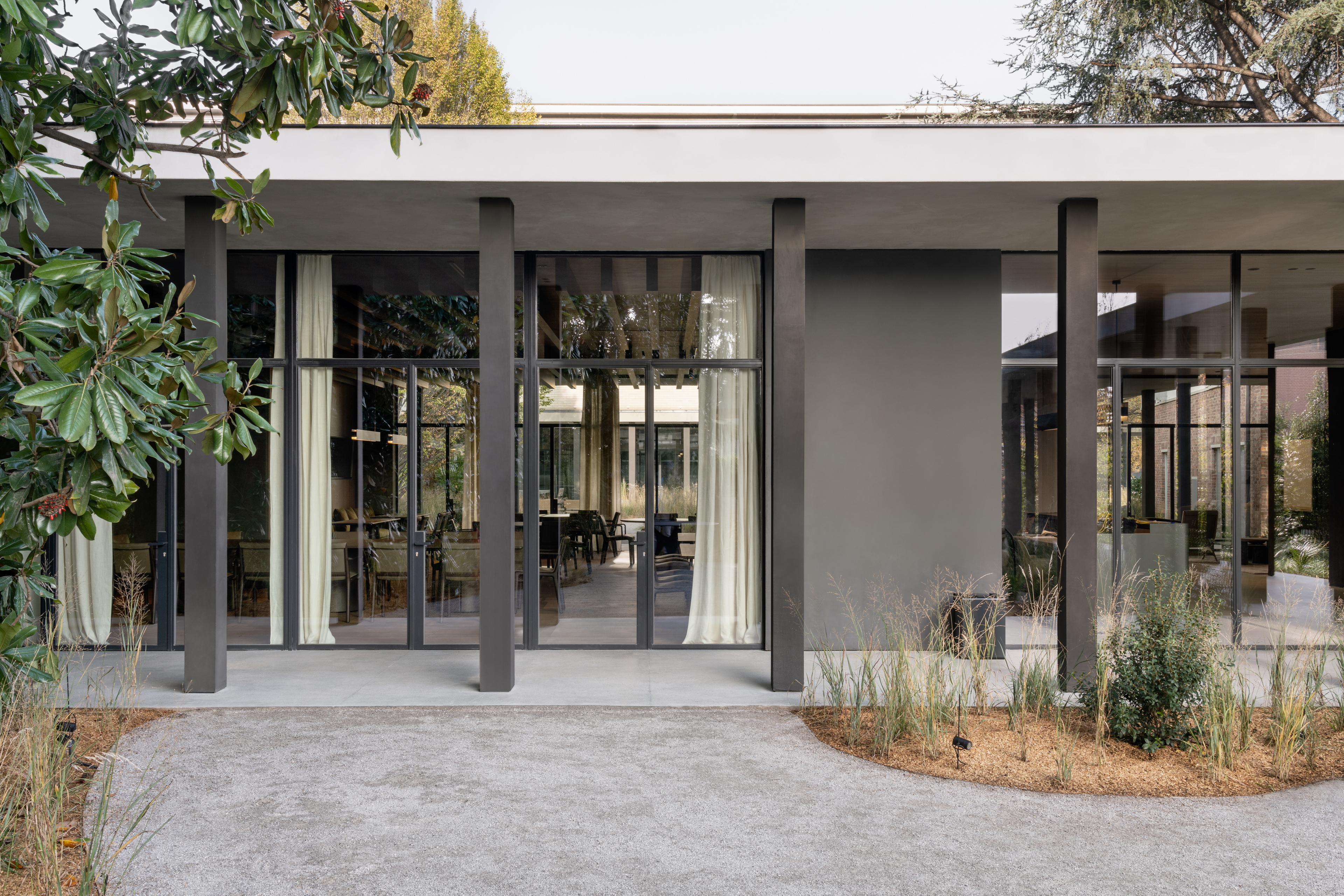 TerraTon Wall Smooth Pepe Nero and Polvere finishing plaster based on natural pozzolans clay, cement and fine-grained mineral binders applied to pillars and walls in the exteriors of the Molteni's headquarters expansion in Giussano. Project by Vincent Van Duysen. Photography: DSL Studio-Delfino Sisto Legnani