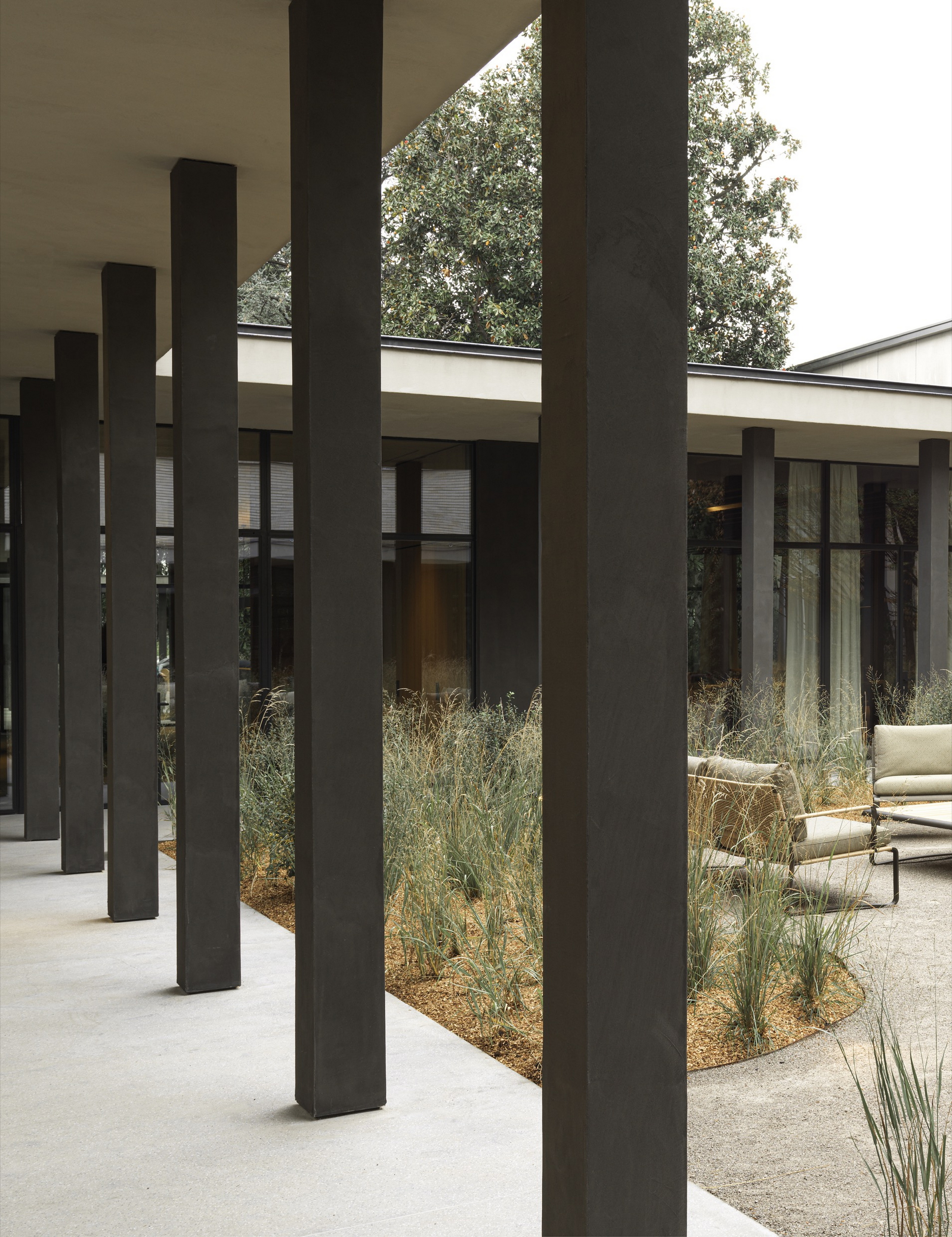 TerraTon Wall Smooth Pepe Nero and Polvere finishing plaster based on natural pozzolans clay, cement and fine-grained mineral binders applied to pillars and walls in the exteriors of the Molteni's headquarters expansion in Giussano. Project by Vincent Van Duysen. Photography: DSL Studio-Delfino Sisto Legnani