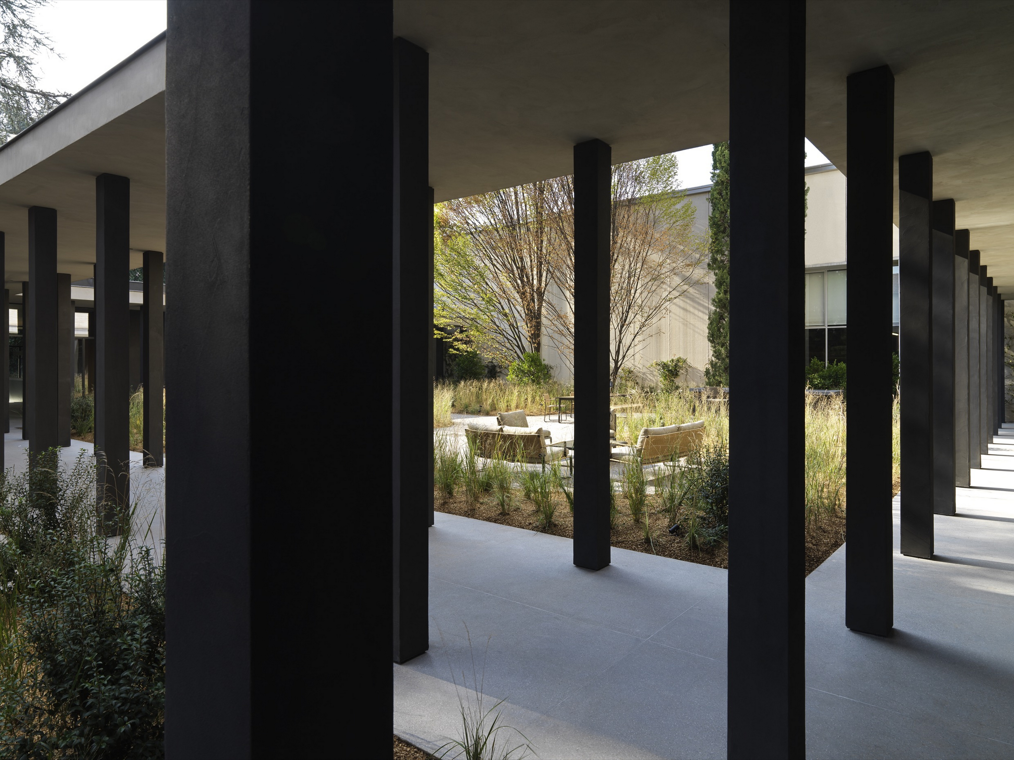 TerraTon Wall Smooth Pepe Nero and Polvere finishing plaster based on natural pozzolans clay, cement and fine-grained mineral binders applied to pillars and walls in the exteriors of the Molteni's headquarters expansion in Giussano. Project by Vincent Van Duysen. Photography: DSL Studio-Delfino Sisto Legnani