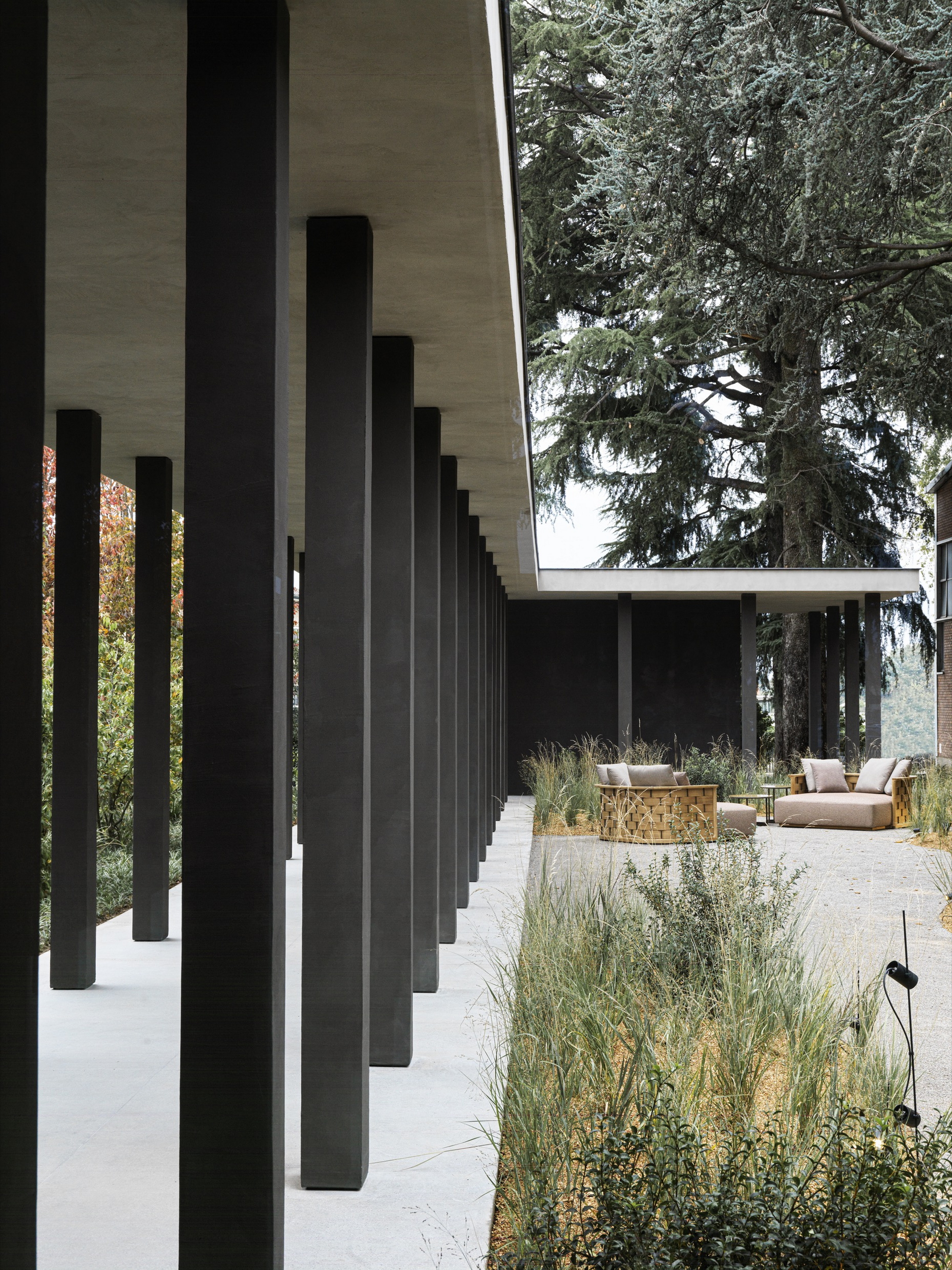 TerraTon Wall Smooth Pepe Nero and Polvere finishing plaster based on natural pozzolans clay, cement and fine-grained mineral binders applied to pillars and walls in the exteriors of the Molteni's headquarters expansion in Giussano. Project by Vincent Van Duysen. Photography: DSL Studio-Delfino Sisto Legnani