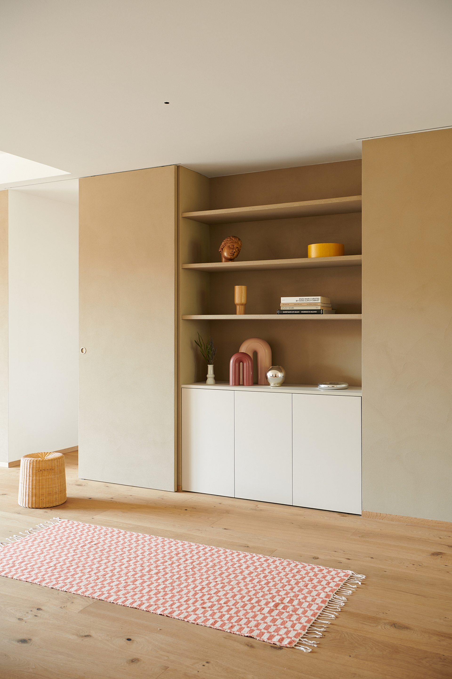 Intonaco di finitura in argilla a grana fine TerraVista Liscio Cannella applicato su mensole, contenitori e pannelli scorrevoli in un per una architettura d'interni a Milano su progetto di Studio Irvine. Foto di Natalia Garcia