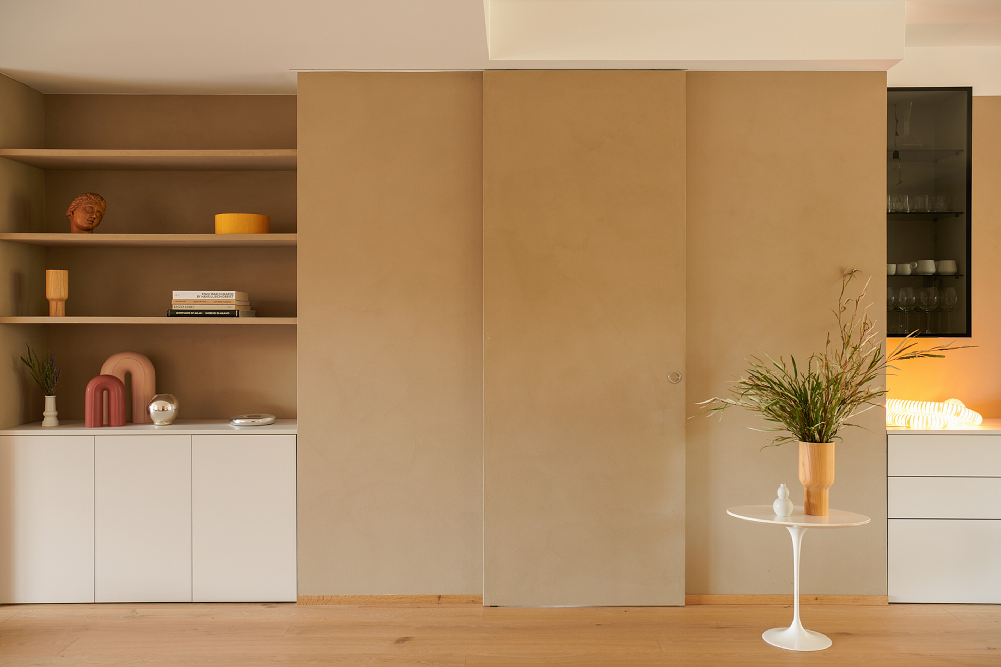 Intonaco di finitura in argilla a grana fine TerraVista Liscio Cannella applicato su mensole, contenitori e pannelli scorrevoli in un per una architettura d'interni a Milano su progetto di Studio Irvine. Foto di Natalia Garcia