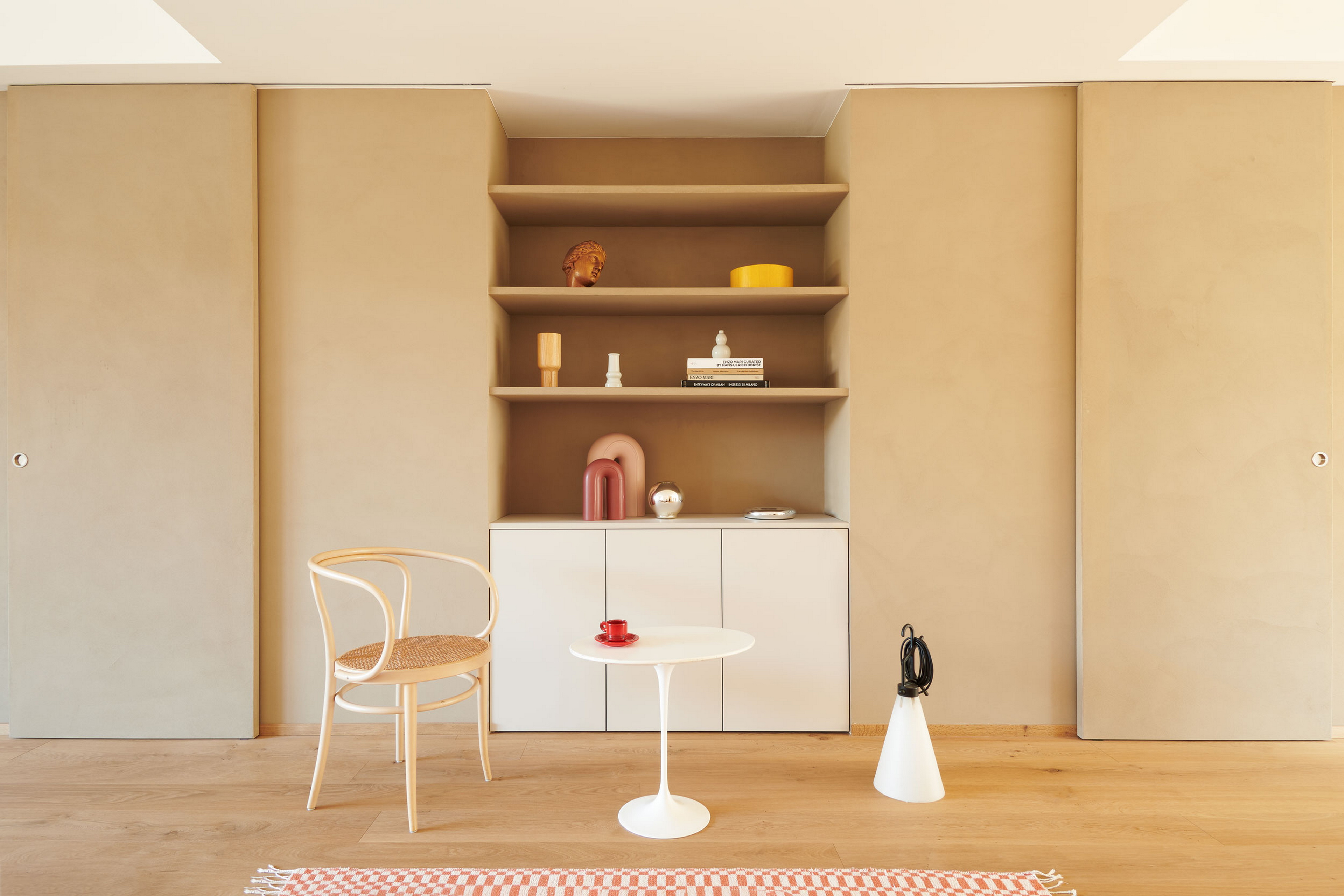 Intonaco di finitura in argilla a grana fine TerraVista Liscio Cannella applicato su mensole, contenitori e pannelli scorrevoli in un per una architettura d'interni a Milano su progetto di Studio Irvine. Foto di Natalia Garcia