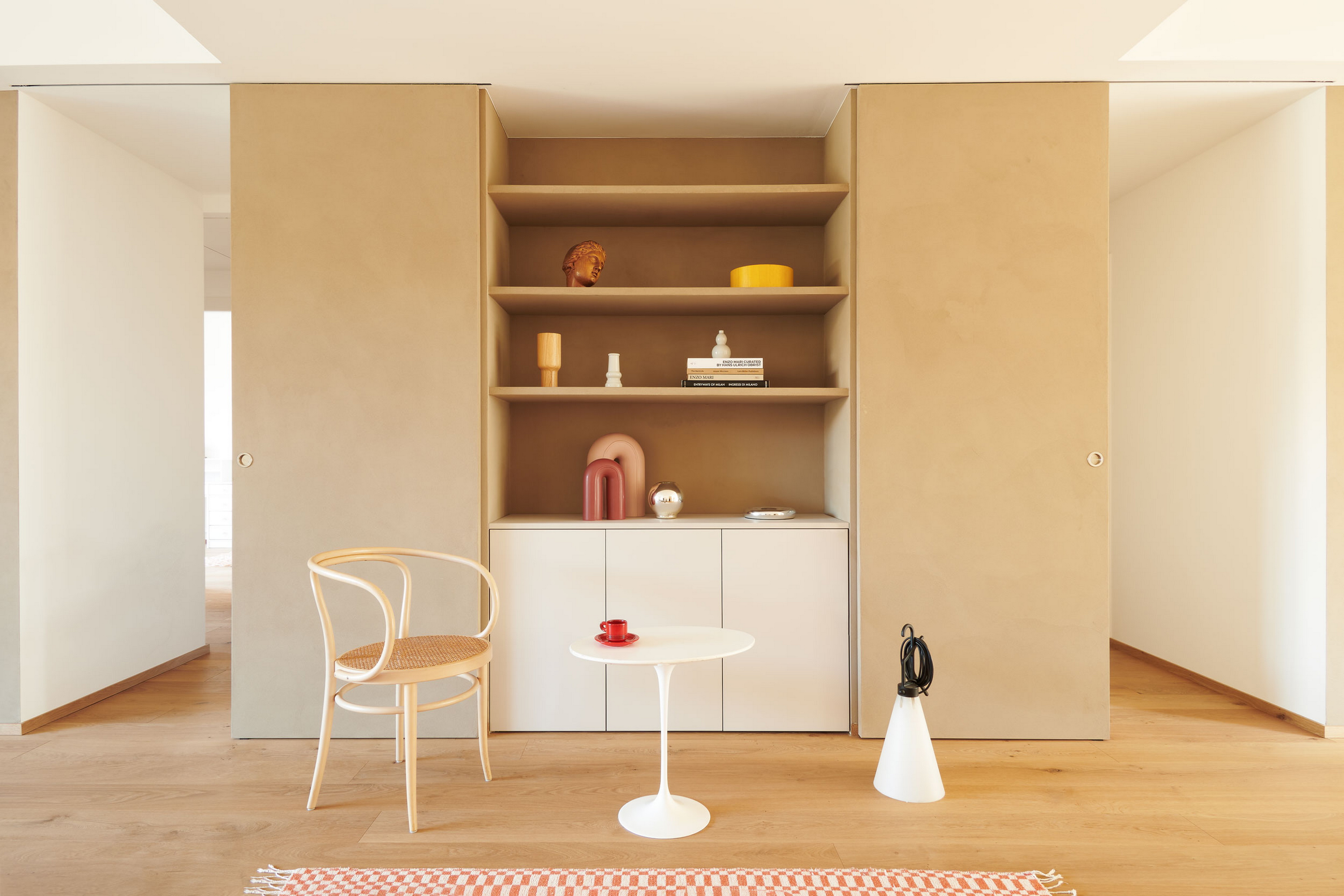 Intonaco di finitura in argilla a grana fine TerraVista Liscio Cannella applicato su mensole, contenitori e pannelli scorrevoli in un per una architettura d'interni a Milano su progetto di Studio Irvine. Foto di Natalia Garcia