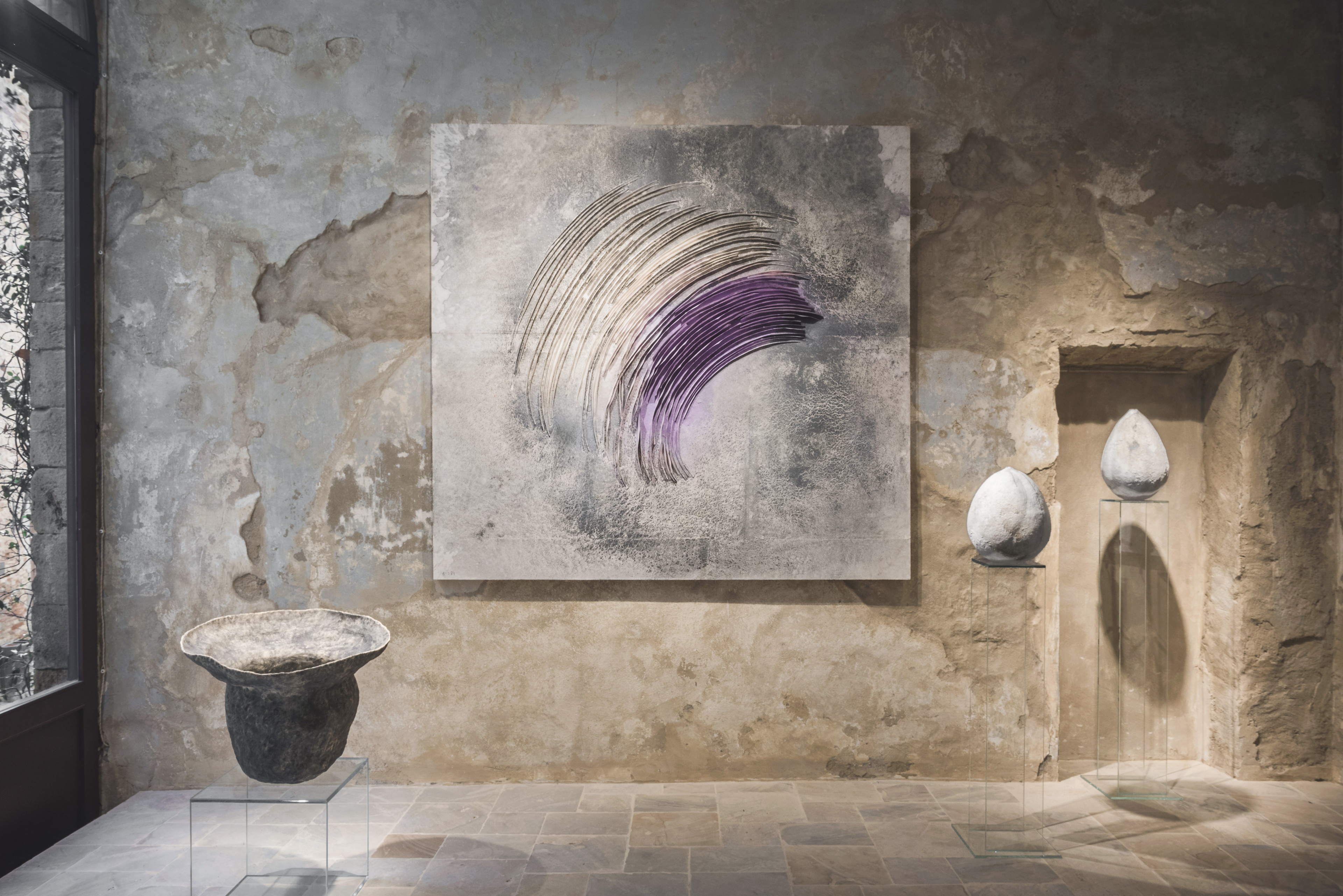 Intonaco di finitura in argilla a grana fine TerraVista Liscio Panna e intonaco in terra cruda a grana grossa MultiTerra Wabi Polvere e Sale Grigio applicati sulle pareti della galleria Kalpa Art Living nel palazzo Bonomini a Volterra. Progetto di Olga Niescier, foto di Simone Stanislai su gentile concessione di Kalpa