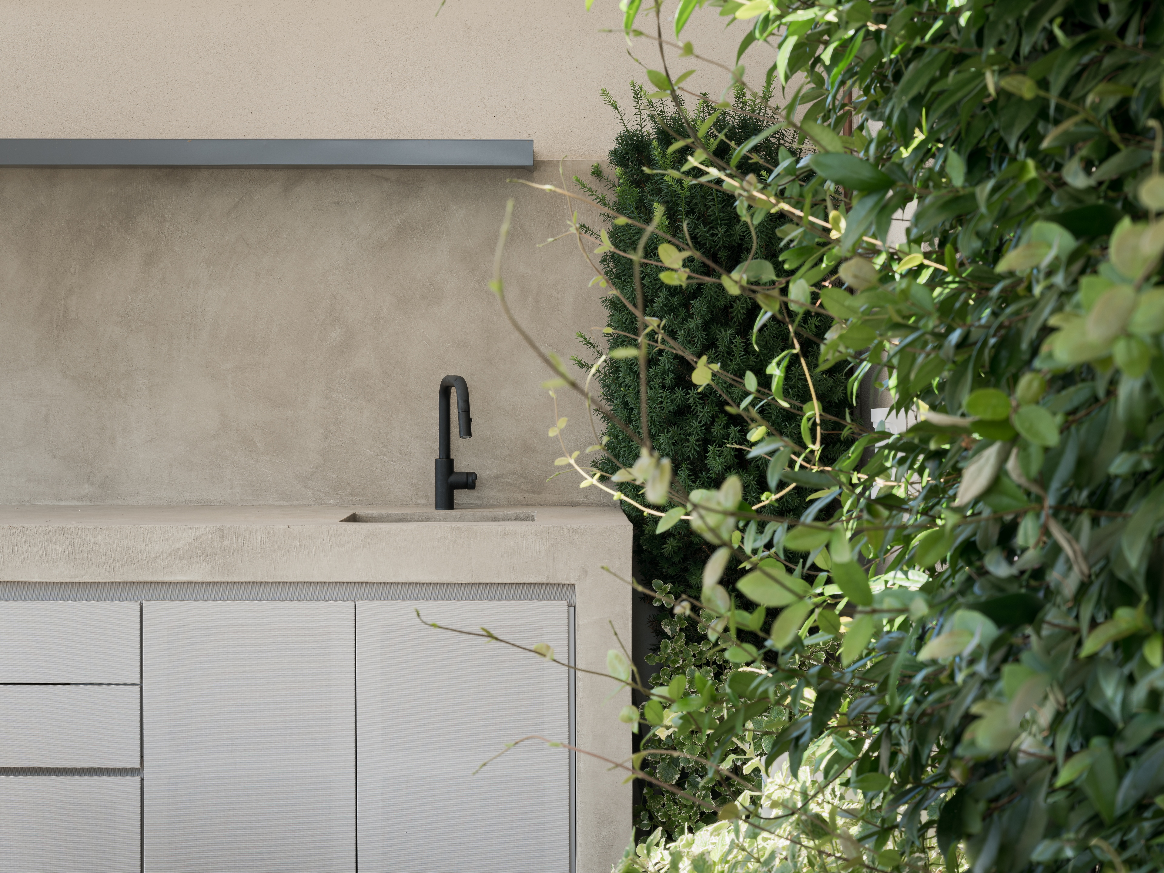 Clay finishes for a penthouse in the centre of Verona. Finishing plaster based on natural pozzolans clay, cement and fine-grained mineral binders TerraTon Wall in a custom color applied to the surfaces of the outdoor kitchen. Project by Emanuele Soldi Architetto Photography: Michele Mascalzoni